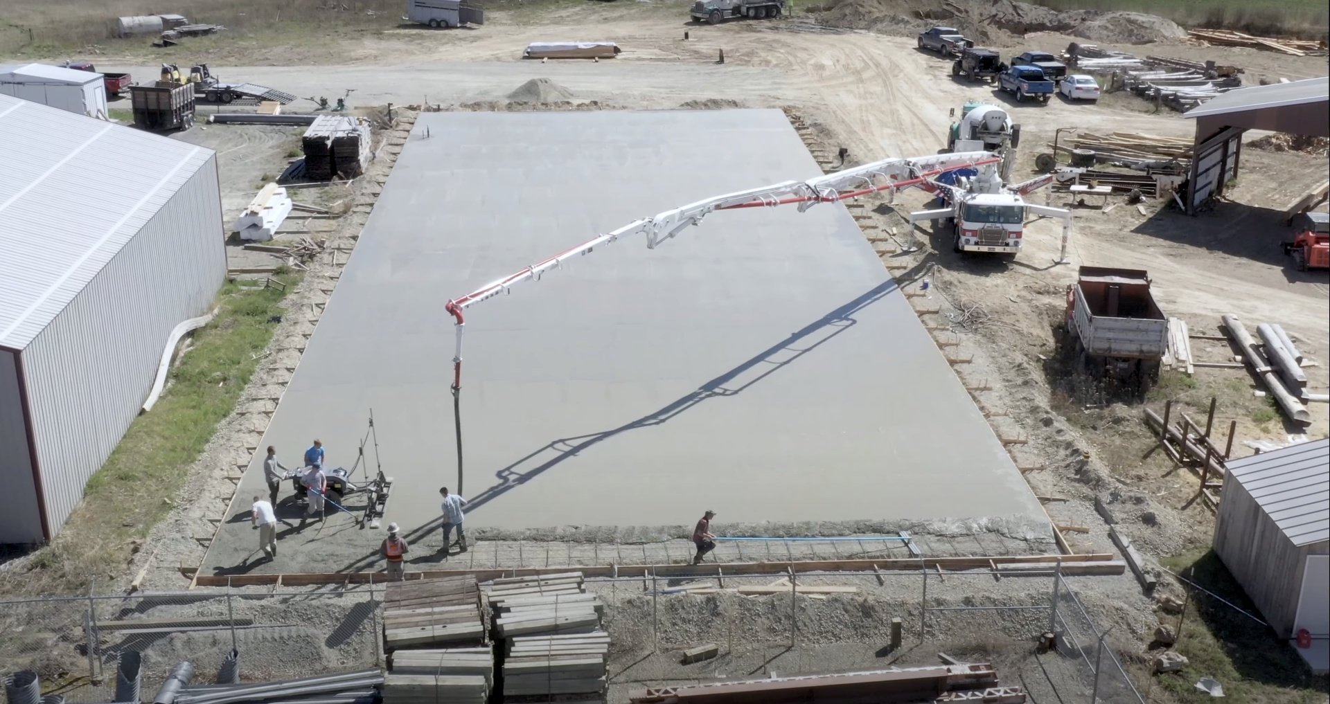 Major commercial concrete foundation project aerial view Large commercial concrete slab pour with pump truck and crew